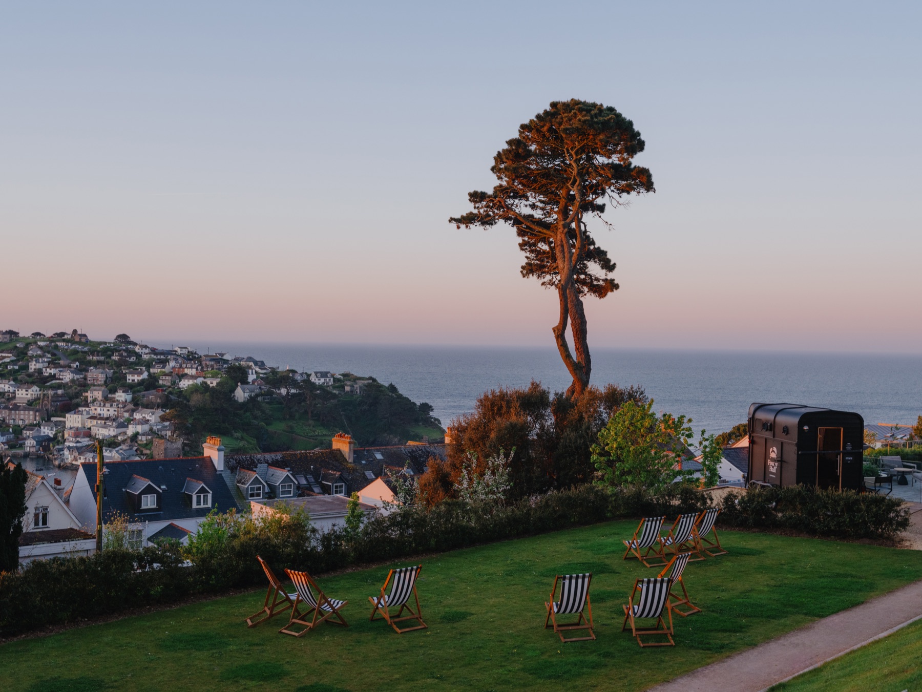 A Sauna Box horsebox sauna in the grounds of Fowey Hall Hotel, Cornwall, at golden hour