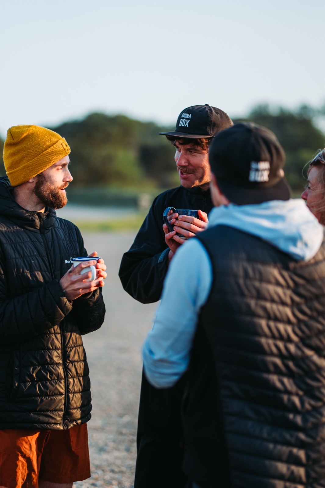 A small group gathered with coffee outside a sauna