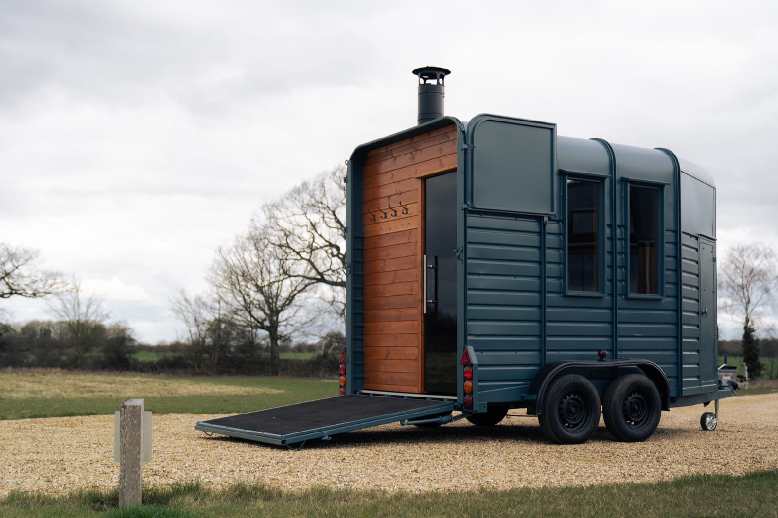 Island Sauna Shack's ramp lowered and cedar door open, ready to welcome guests into the horsebox sauna