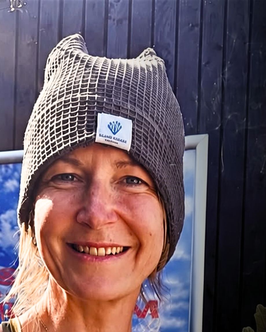 Donna, who runs Island Sauna Shack, smiling in a knitted beanie