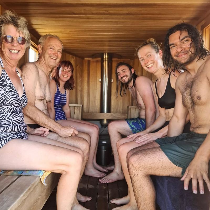 An older couple and younger friends side by side inside a Sauna Box sauna