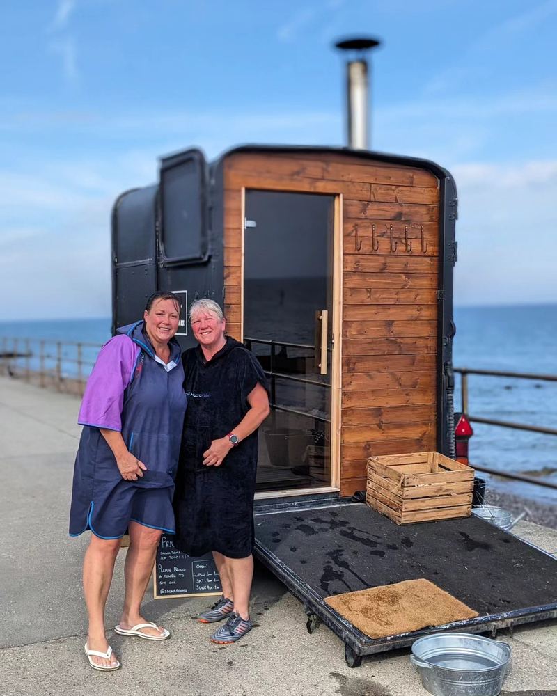 Two women in changing robes at the door of the Sheringham sauna, straight from their morning swim