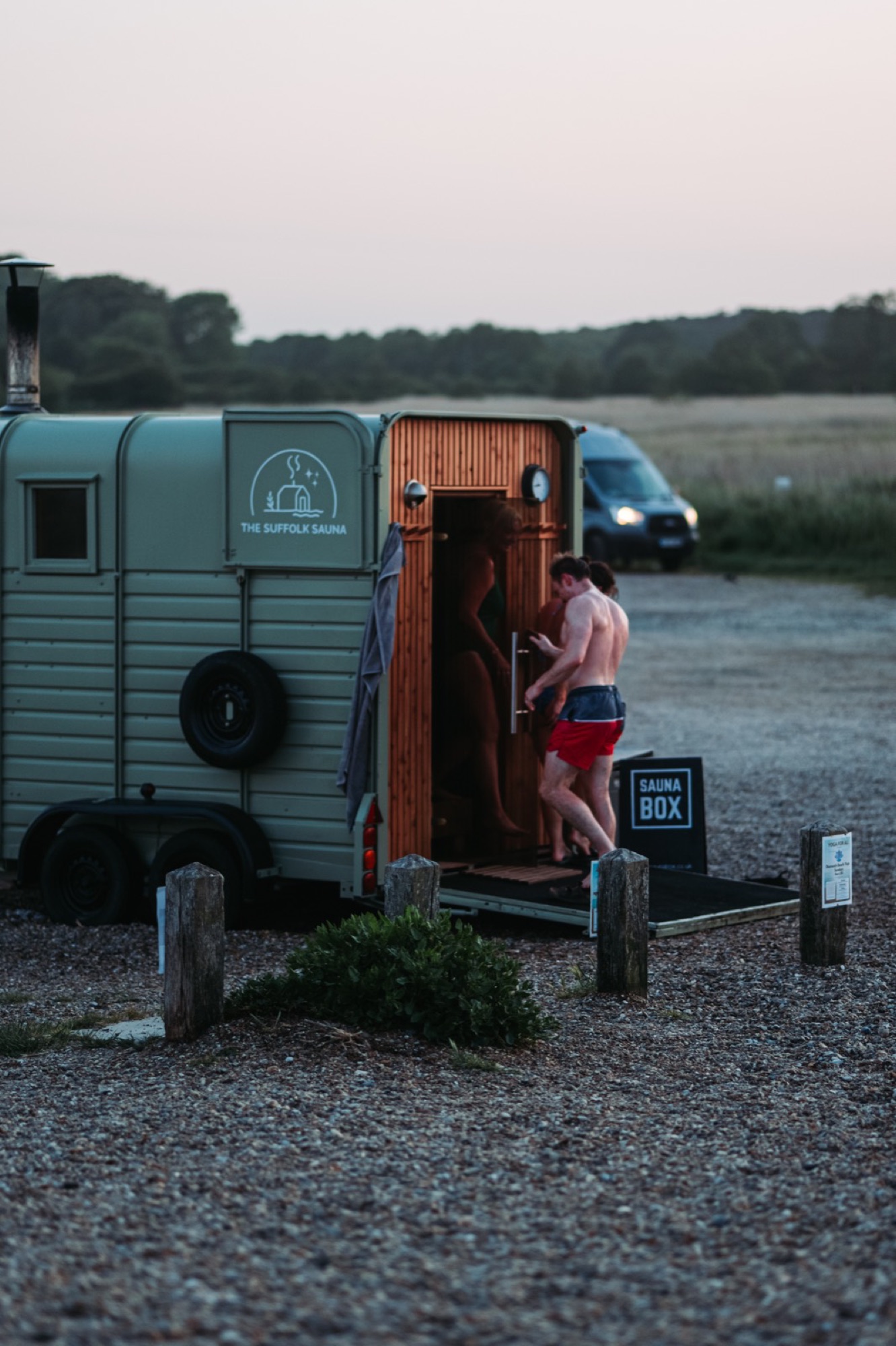 Bathers entering the horsebox sauna at dusk