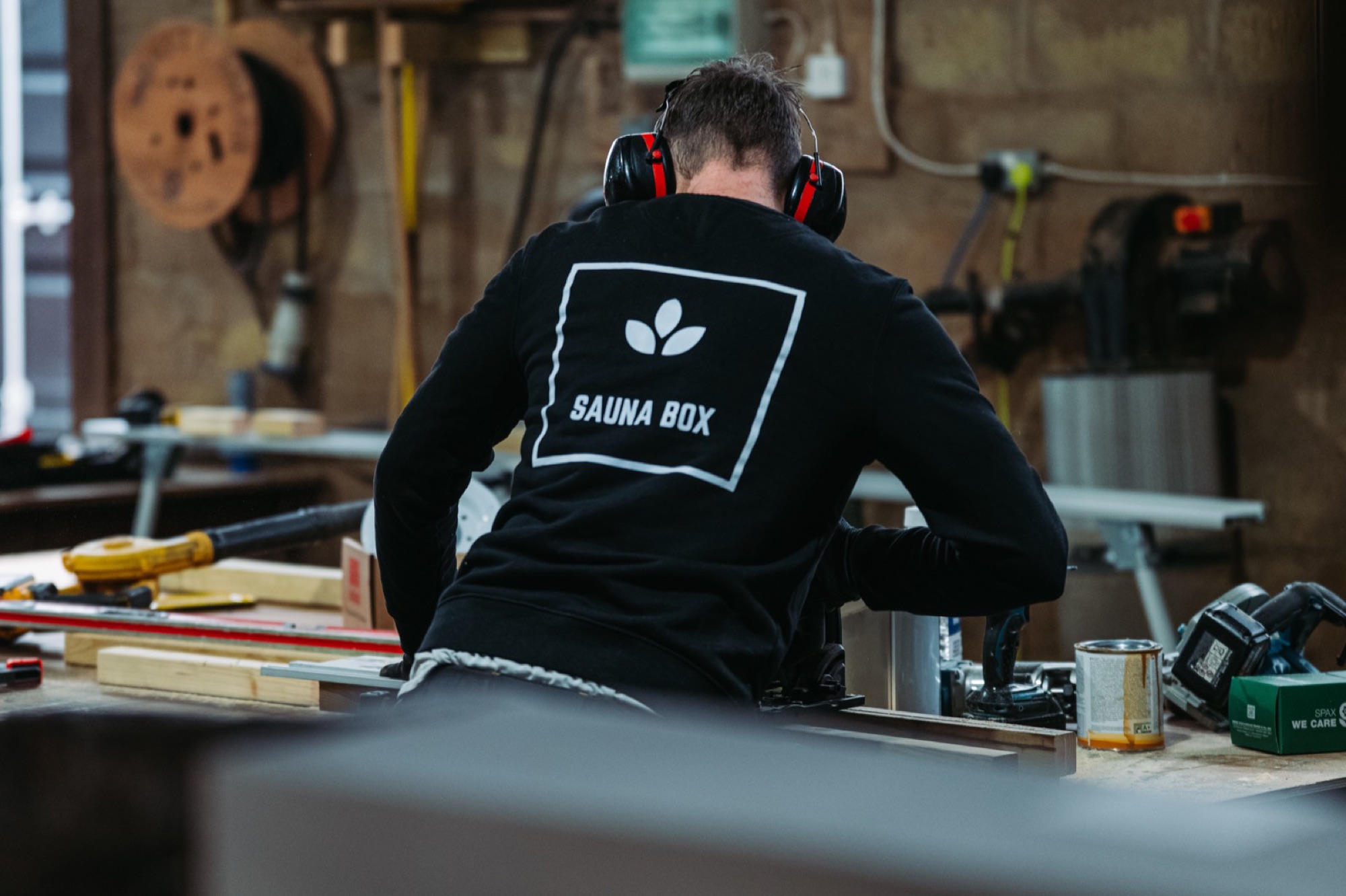 A Sauna Box craftsman measuring timber in the Suffolk workshop